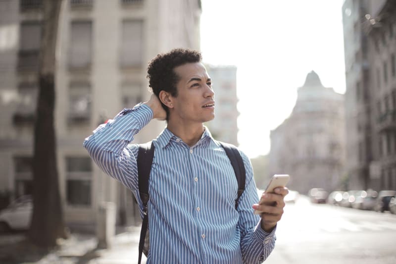 Persona buscando un negocio en Google desde el móvil en la calle
